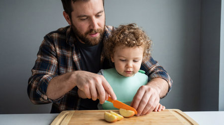 Father teaching young child to safely cut fruit in bright kitchen, focusing on bonding, learning, and early cooking skills together.の素材