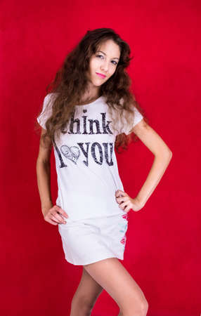 Pretty girl in shirt with inscription on the red backgroundの写真素材