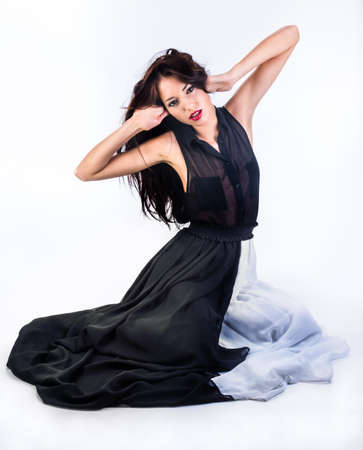 fashion girl sits on the floor in the black-and-white dress on the white backgroundの写真素材