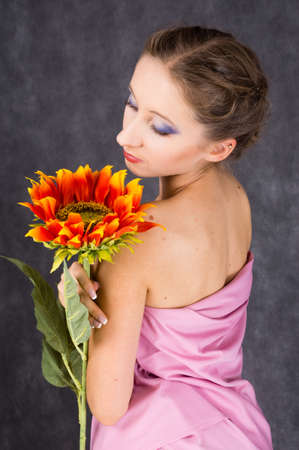 female dressed pink toga with orange  sunflowerの写真素材