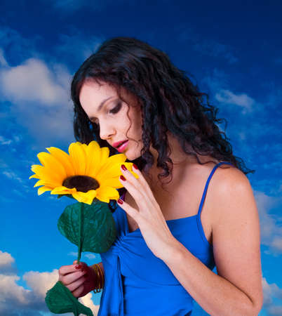 pretty sad female with sunflower over the skyの写真素材