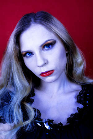 vamp female with blue eyes on the red backgroundの写真素材