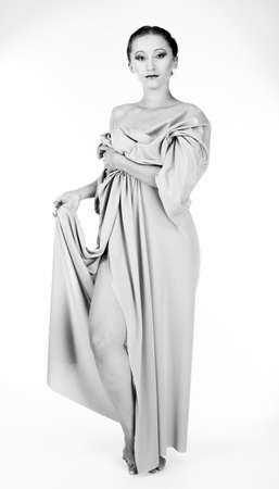 black and white photo of girl weared and posing antique sculotureの写真素材