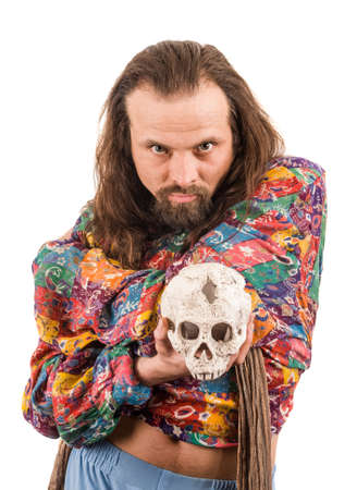 The bearded man in the colour shirt with a skull in his hands isolated on whiteの写真素材