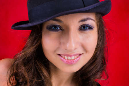smile female wear black hat on red backgroundの写真素材