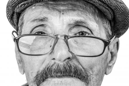 the face of an old man wearing glasses and a capの写真素材