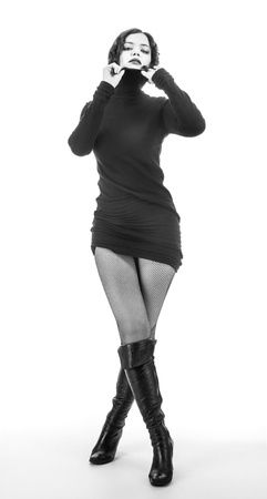 stylish lady in a black dress, black boots and fishnet stockingsの写真素材