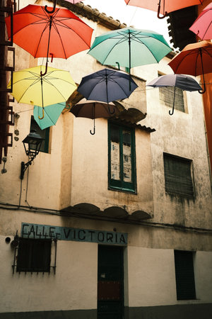 Colorful umbrellas on a street in the city of Sotillos de la Adrada, Spainの写真素材