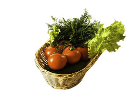 basket of tomatoes, cucumbers and herbs isolated on white backgroundの写真素材