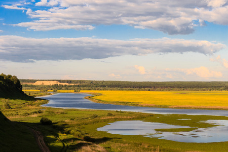 Summer landscape with river and cloudy skyの写真素材