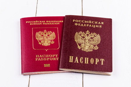 Two passports of the Russian Federation on a white wooden background. The concept of traveling abroad.の写真素材