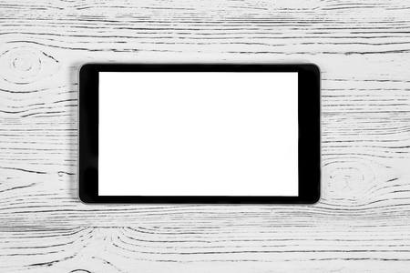 Black tablet with white screen on a wooden table. Copy space display. Blank for design.の写真素材