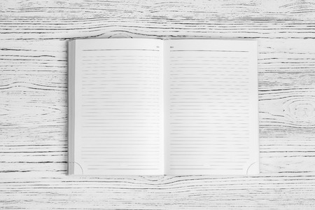 The diary on a white wooden table with a copy space. Blank for design.の写真素材