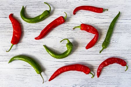 Hot red and green chili pepper on a white wooden vintage background.
