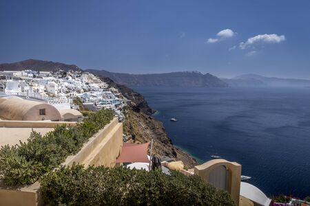 Oia city on Santorini island on a clear sunny day. Cliff overlooking the sea and the caldera.の写真素材