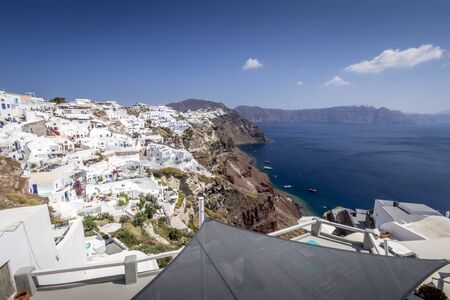 Oia city on Santorini island on a clear sunny day. Cliff overlooking the sea and the caldera.