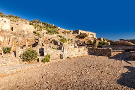 Old buildings and ruins of Spinalonga on a sunny day. Crete, Greece, Aegean sea.の写真素材