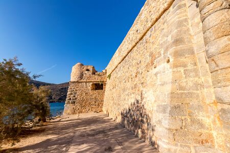 Old buildings and ruins of Spinalonga on a sunny day. Crete, Greece, Aegean sea.