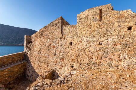 Old buildings and ruins of Spinalonga on a sunny day. Crete, Greece, Aegean sea.