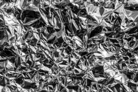 Texture of crumpled aluminum kitchen foil. Silver abstract blank for design.の写真素材