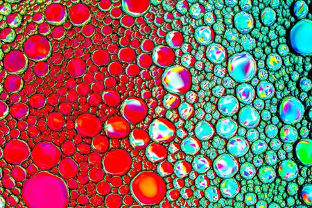 Top view on colorful drops of oil on the water. Circles and ovals. Abstract bright background for...