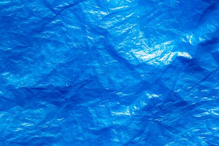 Texture of crumpled blue plastic trash bag. Abstract background for design with copy space.の写真素材