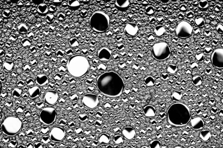 Top view on black and white drops of oil on the water. Circles and ovals. Monochrome abstract...