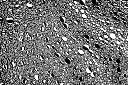 Top view on black and white drops of oil on the water. Circles and ovals. Monochrome abstract background for design with reflected refracted lines.の写真素材