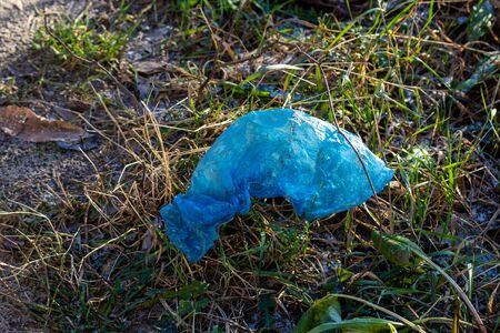 Plastic garbage thrown out in nature among grass. Sunny autumn day. The concept of ecology and environmental pollution.の写真素材