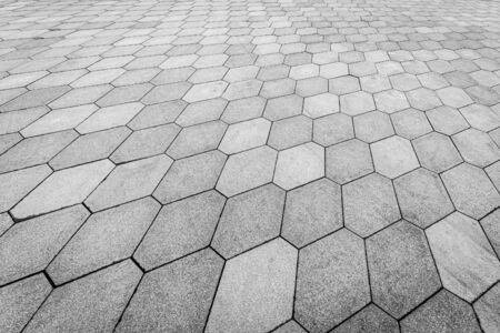 Top view on paving stone road. Old pavement of granite texture. Street hexagonal cobblestone sidewalk. Abstract background for design.の写真素材