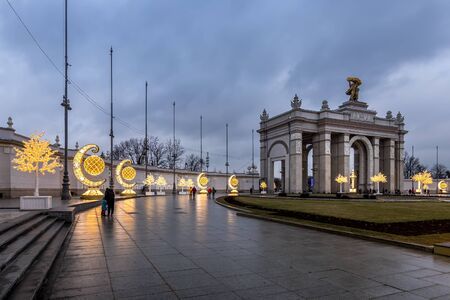 MOSCOW, RUSSIA - DECEMBER 11, 2019: New Year lights at VDNH. Glowing Christmas decorations at evening in rainy weather. Wet pavement.のeditorial素材