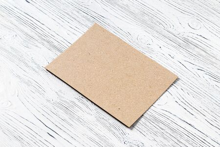 Cardboard on a white wooden table. Abstract background for design. Art stylized baner or mock up with copy space for a text.の写真素材