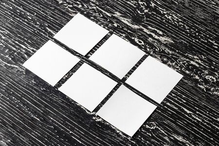 White paper sheets on a black wooden table. Abstract background for design. Art stylized baner or...