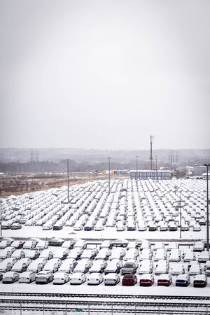 Volkswagen, Russia, Kaluga - JANUARY 31, 2019: New cars covered with snow and parked in a distribution center on a cloudy day in the winter, a car factory. Parking in the open air.のeditorial素材