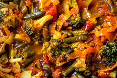 Stewed vegetables in a pan. Cooking process. Vegan food. Broccoli, onions, carrots, green beans and peppers with ketchup.の写真素材