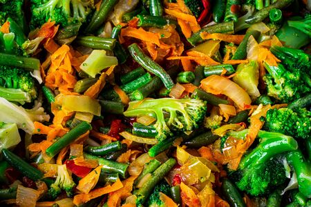 Stewed vegetables in a pan. Cooking process. Vegan food. Broccoli, onions, carrots, green beans and peppers.の写真素材
