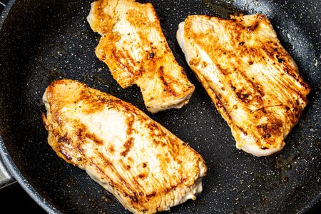 Turkey steak grilled in a pan. The cooking process.