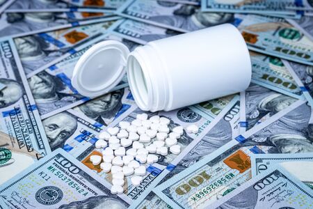 Heart-shaped pills on the background of hundred-dollar bills. The concept of the expensive cost of...