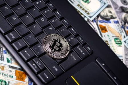 Dollar bills, black keyword and metal souvenir bitcoin. The concept of electronic money, online...