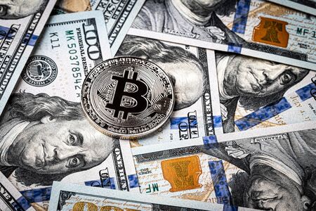 Dollar bills and metal souvenir bitcoin. The concept of electronic money and commerce....