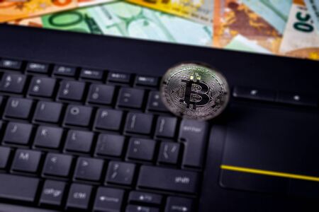 Euro bills, black keyword and metal souvenir bitcoin. The concept of electronic money, online trading, mining and commerce. Cryptocurrency and cash.の写真素材