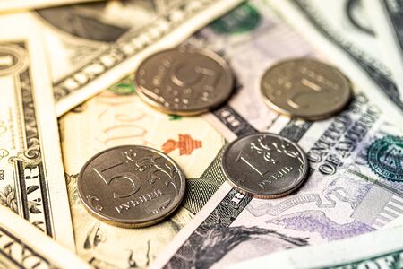 Ruble coins on the background of dollar bills. Exchange rate concept.