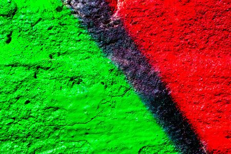 Fragment of colorful graffiti painted on a concrete wall. Bright red, black and green abstract background for design.の写真素材