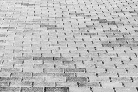 Top view on black and white paving stone road. Old pavement of granite texture. Street cobblestone...