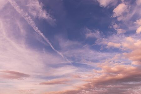 Cloudy sky at sunset or sunrise with sunlight. Abstract backdrop for design.