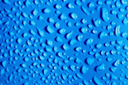 Macro water drops texture on a blue backdrop. Abstract pattern or blank for design.の写真素材