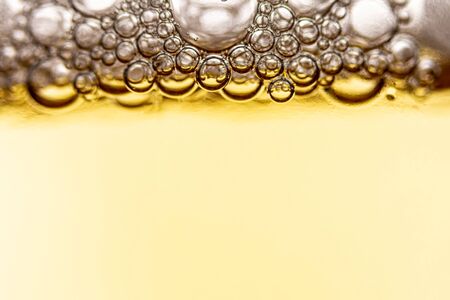 Texture of foam and bubbles in light beer. Abstract background for design.