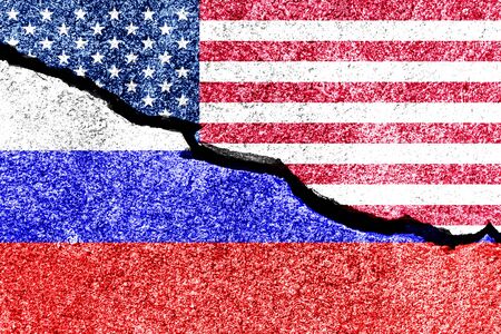 The crack between the Russian Federation and USA flags on the concrete wall. The concept of sanctions, trade war, the deterioration of diplomatic relations, confrontation and severance of agreements.の写真素材