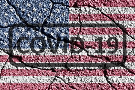 USA flag on cracked concrete wall. The concept of COVID-19 or coronavirus pandemic in country. Abstract symbol of problems with pandemic.の写真素材