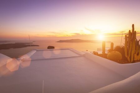Sunset overlooking the caldera and the sea in the village of Imerovigli on the island of Santorini in the summer. Greece. White roof on a foreground.の写真素材